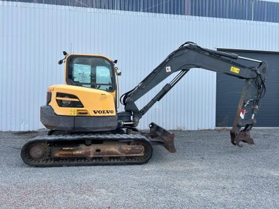 a small excavator that is parked in front of a building