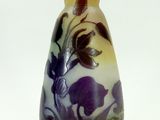un vase orné d'une fleur violette sur un fond blanc