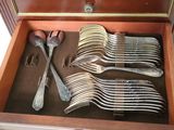 many forks and spoons in a wooden box