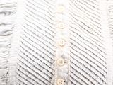 an image of a white blouse with ruffles and buttons