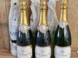 three bottles of champagne are lined up on a wooden table