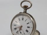 a silver pocket watch with roman numerals on it