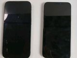 two black iphones sitting next to each other on a table