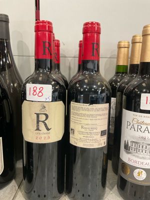 several bottles of red wine are lined up on a counter