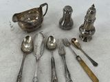 an assortment of silverware including spoons, forks, and a saucer