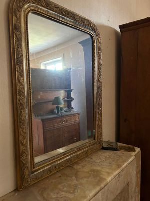un miroir posé sur une cheminée dans une pièce