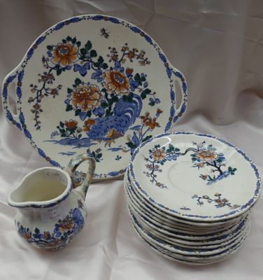 de nombreuses assiettes et tasses sur une table, avec un pichet