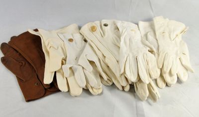 several pairs of white leather gloves on a white surface