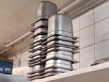 several pans stacked on top of each other on a shelf in a kitchen