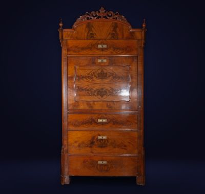 an antique chest of drawers with a carved top on a dark background
