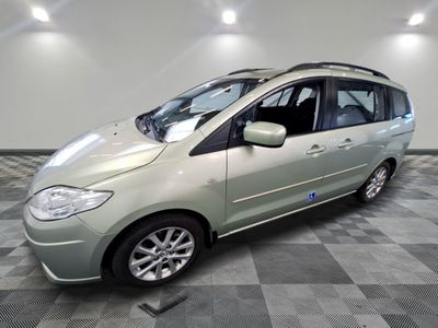 une photo d'un monospace vert garé dans un showroom