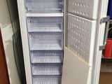 un réfrigérateur blanc dont la porte est ouverte, dans un garage