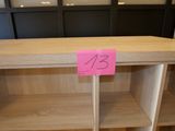 une étagère en bois sur laquelle est collé un autocollant rose