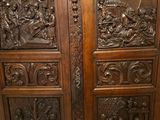 carved wood doors with carvings of people and animals on them