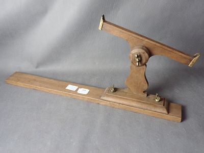 un objet en bois muni d'une poignée en métal, sur fond gris