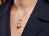 a woman wearing a black blazer and a gold necklace