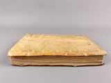 an old book sitting on top of a table on a gray surface