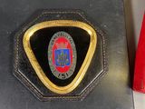 a black wallet with a badge on it next to a red wallet