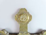 a close up of a gold clock on a white wall