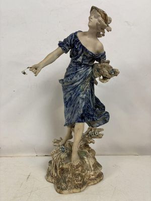 une figurine représentant une femme tenant un panier de fleurs