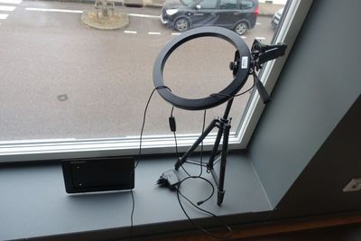 une image représentant une photo d'un appareil photo posé sur un trépied devant une fenêtre