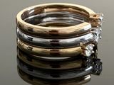a stack of three rings with diamonds on top of a table