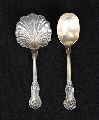 two spoons and a spoon rest on a black surface