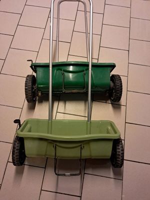 two lawn mowers sitting on the floor next to each other