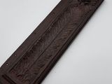 a close up of a wooden plaque on a white surface