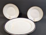 Trois assiettes blanches à bord bleu sont posées sur une table