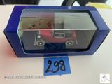 un petit camion jouet dans une boîte bleue posée sur une table