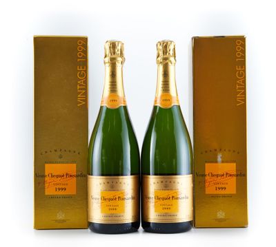 deux bouteilles de champagne devant un coffret doré