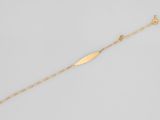 un bracelet plaqué or orné d'une breloque en forme de feuille