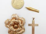 an image of a cross, a pen, and a gold flower brooch