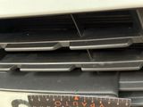a close up of a car grille with a ruler in front of it