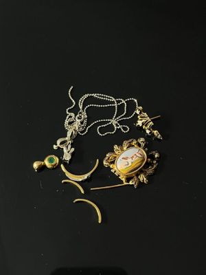 a close up of a necklace on a table with a cell phone