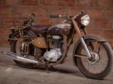 a old motorcycle that is parked in front of a brick wall
