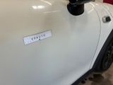 a close up of a white car with a sticker on it