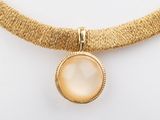 un collier en or orné d'un pendentif en nacre
