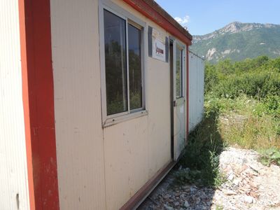 une photo d'un petit bâtiment avec une montagne en arrière-plan