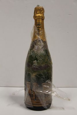a bottle of champagne wrapped in plastic on a table