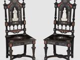 a pair of carved chairs with carvings on the back of them