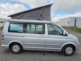 a silver van parked in a parking lot with a tent on top of it