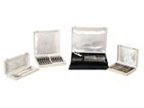 three open silverware boxes with silverware in them on a white surface