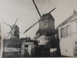 a black and white photo of a windmill and a telephone booth