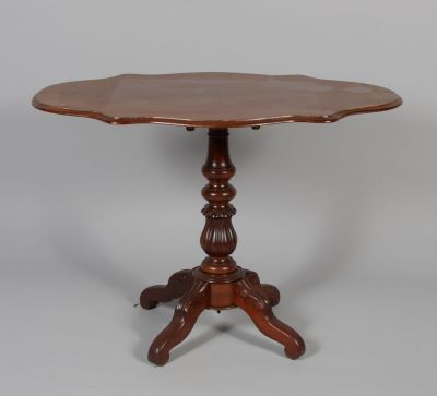 a wooden table with a flower shaped top on a pedestal