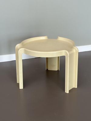 table en plastique jaune à deux pieds dans une pièce aux murs gris