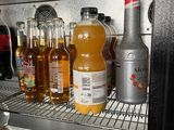 many bottles of alcohol on the shelves of a refrigerator