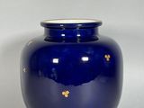 un vase bleu orné d'une décoration dorée