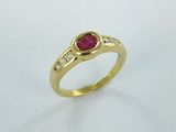 gros plan d'une bague en or avec un rubis et des diamants